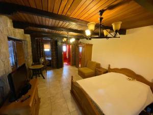 1 dormitorio con 1 cama y TV en una habitación en Семейный комплекс для отдыха en Pečurice