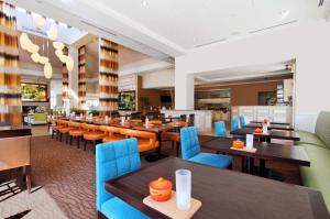 a restaurant with wooden tables and blue chairs at Hilton Garden Inn Saint Charles in Saint Charles