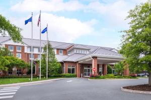 un hotel con bandiere di fronte a un edificio di Hilton Garden Inn Charlottesville a Charlottesville