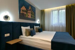 een slaapkamer met een groot bed met een blauw hoofdeinde bij Prinz Gregor in Braşov