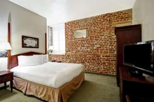 um quarto de hotel com uma cama e uma parede de tijolos em Embassy Suites Charleston - Historic District em Charleston