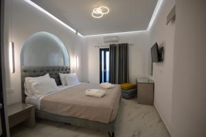 a large bedroom with a large bed with an archigunigunigun at Avant Garde Firostefani in Firostefani