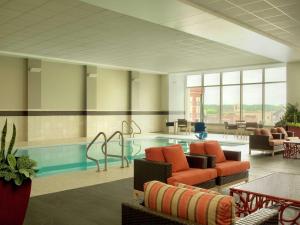 een ziekenhuislobby met een zwembad en stoelen en tafels bij DoubleTree by Hilton Hotel Cedar Rapids Convention Complex in Cedar Rapids