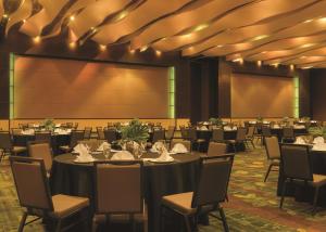 a conference room with tables and chairs and a projection screen at DoubleTree by Hilton Hotel Cedar Rapids Convention Complex in Cedar Rapids