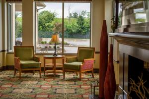 a living room with three chairs and a fireplace at Hilton Garden Inn Cleveland East / Mayfield Village in Mayfield