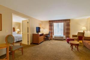 a hotel room with a bed and a couch and a television at Hilton Garden Inn Cleveland East / Mayfield Village in Mayfield