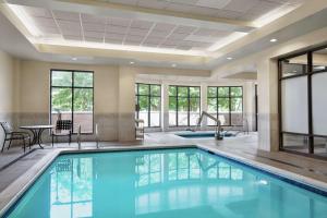 una piscina en el vestíbulo del hotel con mesa y sillas en Hilton Garden Inn Charlotte/Ayrsley, en Charlotte