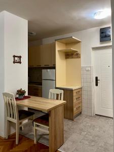 a kitchen with a wooden table and two chairs at Apartment Welcome in Bar