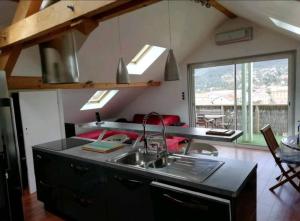 uma cozinha com um lavatório e um balcão com uma mesa em Appartement Cosy em Gérardmer