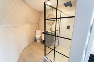 a bathroom with a toilet and a glass wall at Gravity Luxury Domes in South Maitland