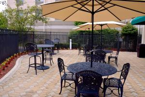 a patio with tables and chairs and an umbrella at Hilton Garden Inn Columbus/Polaris in Columbus