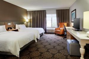 una camera d'albergo con due letti e una scrivania di Hilton Garden Inn Columbus/Polaris a Columbus