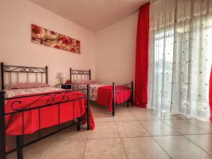 1 dormitorio con 2 camas y ventana en Casa Vacanze Villa Marisol, en Vico Equense