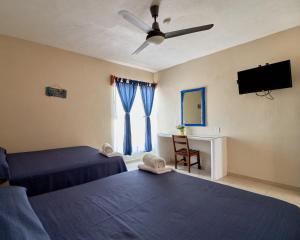 a bedroom with two beds and a ceiling fan at Bungalows Las Hamacas in San Patricio Melaque