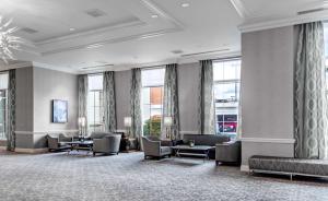 a waiting room with chairs and tables and windows at Hilton Columbus at Easton in Columbus