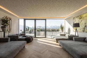 un soggiorno con divani e una grande finestra di DAS GERSTL Alpine Retreat a Malles Venosta