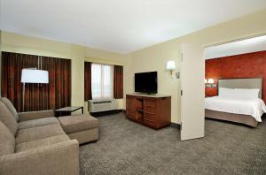 a hotel room with a bed and a couch and a television at Hampton Inn & Suites Columbus-Downtown, Ohio in Columbus