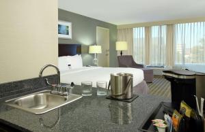 a hotel room with a bed and a sink at Doubletree by Hilton Newark in Newark