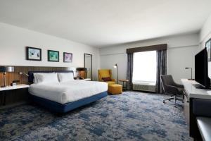 a hotel room with a bed and a desk and a television at Hilton Garden Inn Champaign/ Urbana in Champaign