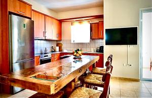 a kitchen with a wooden table and a refrigerator at Atreas’ Art Studio in Chania Town +11 photos