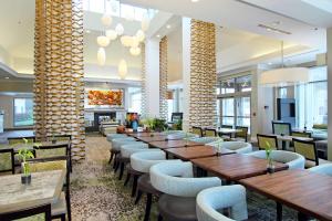 um restaurante com mesas e cadeiras de madeira e uma lareira em Hilton Garden Inn Columbus-University Area em Columbus