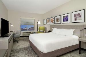 a hotel room with a bed and a flat screen tv at Hilton Garden Inn Columbus-University Area in Columbus