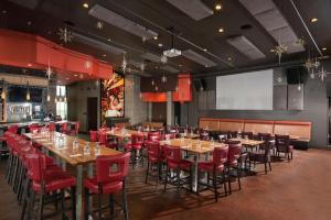 a restaurant with wooden tables and red chairs at The Broadway Columbia - a DoubleTree by Hilton Hotel in Columbia