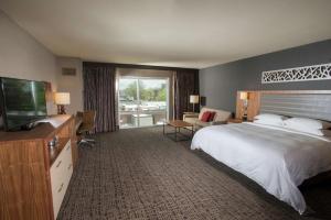 a hotel room with a bed and a flat screen tv at The Broadway Columbia - a DoubleTree by Hilton Hotel in Columbia