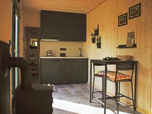 a kitchen with black cabinets and a bar stool in it at Casita Colombia - Glamping v Brdech - Příbram 