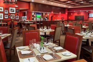 a restaurant with tables and chairs and a bar at DoubleTree by Hilton Cincinnati Airport in Hebron