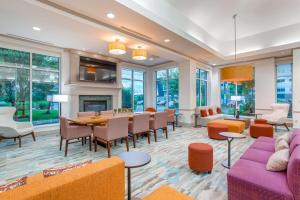 a large living room with a table and chairs at Hilton Garden Inn Cincinnati/Sharonville in Sharonville