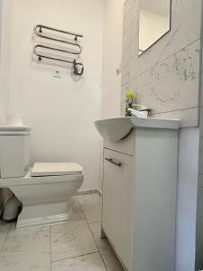 a white bathroom with a toilet and a sink at Familly Apartament 3 in Międzyzdroje
