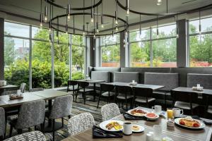 un restaurante con mesas, sillas y ventanas en Hilton Garden Inn Corvallis, en Corvallis