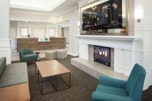 a lobby with a fireplace and two chairs and a table at Hilton Garden Inn Dallas/Allen in Allen