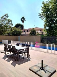 un patio con mesa, sillas y una valla en Experience Valencia Bnb - Luxury Apartment Naquera Chalet 298 con Piscina en Náquera