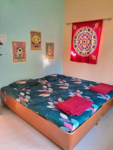 - un lit avec une couette colorée et une peinture murale dans l'établissement Bageecha B&B-Jal, à Alibaug