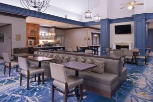 a restaurant with tables and chairs and a fireplace at Homewood Suites by Hilton Dallas-Lewisville in Lewisville