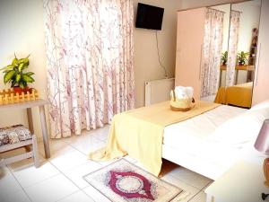 Cette chambre comprend un lit et une table avec une couverture jaune. dans l'établissement Duka's Gardenhouse, à Skopelos