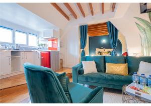 uma sala de estar com um sofá azul e uma cozinha em Le Cocon de la Cathédrale em Évreux
