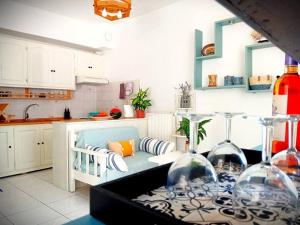 a kitchen with a couch and a table with wine glasses at Duka's Gardenhouse in Skopelos Town