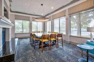 comedor con mesa, sillas y ventanas en Hilton Garden Inn Dayton/ Beavercreek, en Beavercreek