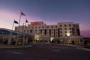 a building with two flags in front of it at Hilton Garden Inn Dayton South - Austin Landing in Springboro