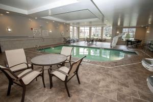 a swimming pool with tables and chairs and a table and a tablektop at Hilton Garden Inn Dayton South - Austin Landing in Springboro