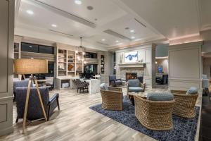 Hilton Dallas/Rockwall Lakefront Hotel في روكوول: غرفة معيشة كبيرة مع كراسي ومدفأة