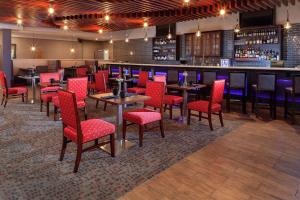 a restaurant with red chairs and tables and a bar at DoubleTree Suites by Hilton Dayton/Miamisburg in Miamisburg