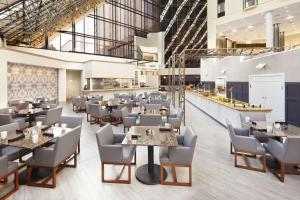 a restaurant with tables and chairs in a building at DoubleTree by Hilton Dallas Near the Galleria in Dallas