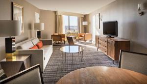 a hotel room with a couch and a television at DoubleTree by Hilton Dallas Near the Galleria in Dallas