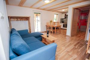 uma sala de estar com um sofá azul e uma mesa em Apartmaji Pri Kozmavo - Little House em Bohinj
