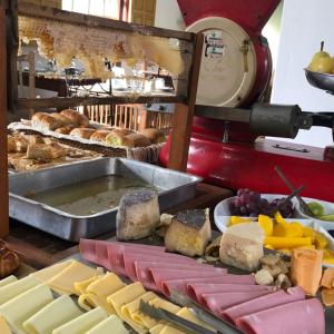 a buffet with different types of cheese and bread at Pousada Vó Iris - Tiradentes Mg in Tiradentes