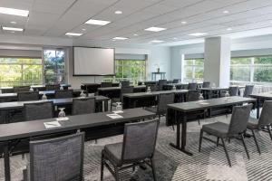 Hilton Garden Inn Arlington/Courthouse Plaza في أرلينغتون: قاعة اجتماعات مع طاولات وكراسي وشاشة